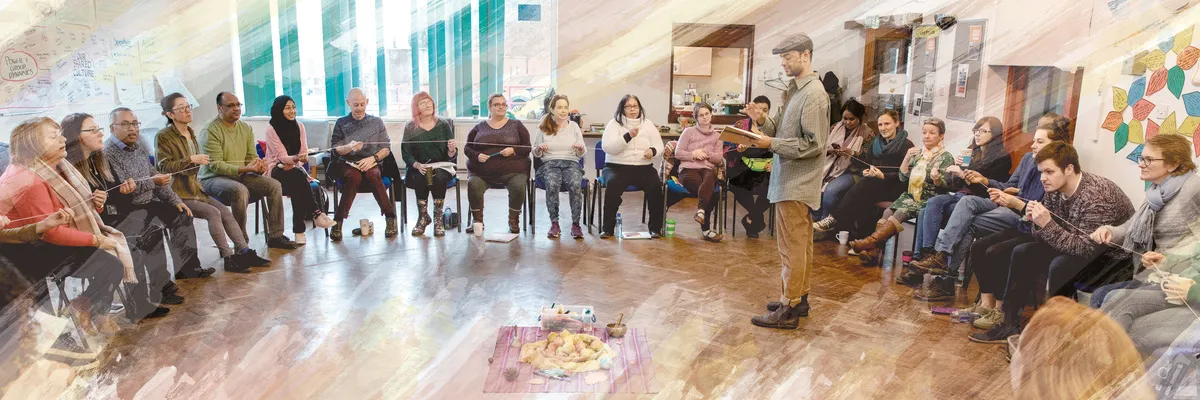 A large circle of participants passing a thread between them